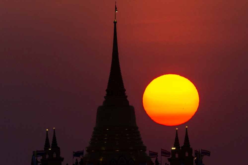 The sun sets behind Wat Saket Temple, or Golden Mount in Bangkok, Thailand, March 15, 2022. Reuters/Athit Perawongmetha