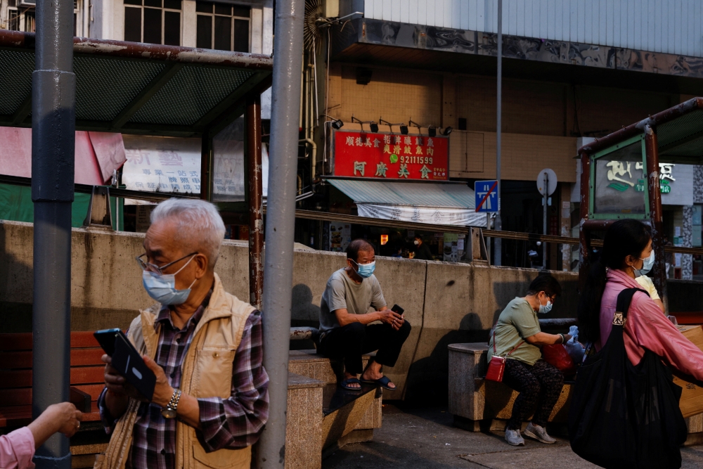 People wear face masks at a park during the coronavirus disease (COVID-19) pandemic in Hong Kong, China, March 16, 2022. REUTERS/Tyrone Siu