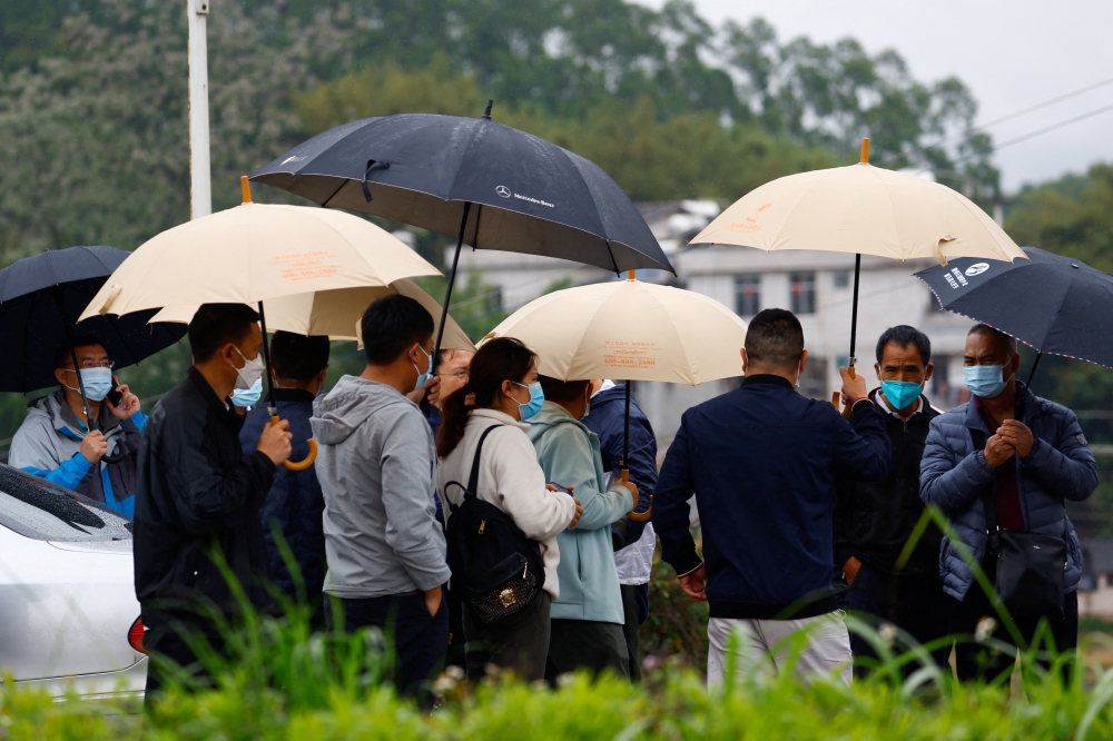 People, some of who are believed to be relatives of victims, arrive at the entrance of Lu village near the site where a China Eastern Airlines Boeing 737-800 plane flying from Kunming to Guangzhou crashed, in Wuzhou, Guangxi Zhuang Autonomous Region, China March 23, 2022. REUTERS/Carlos Garcia Rawlins