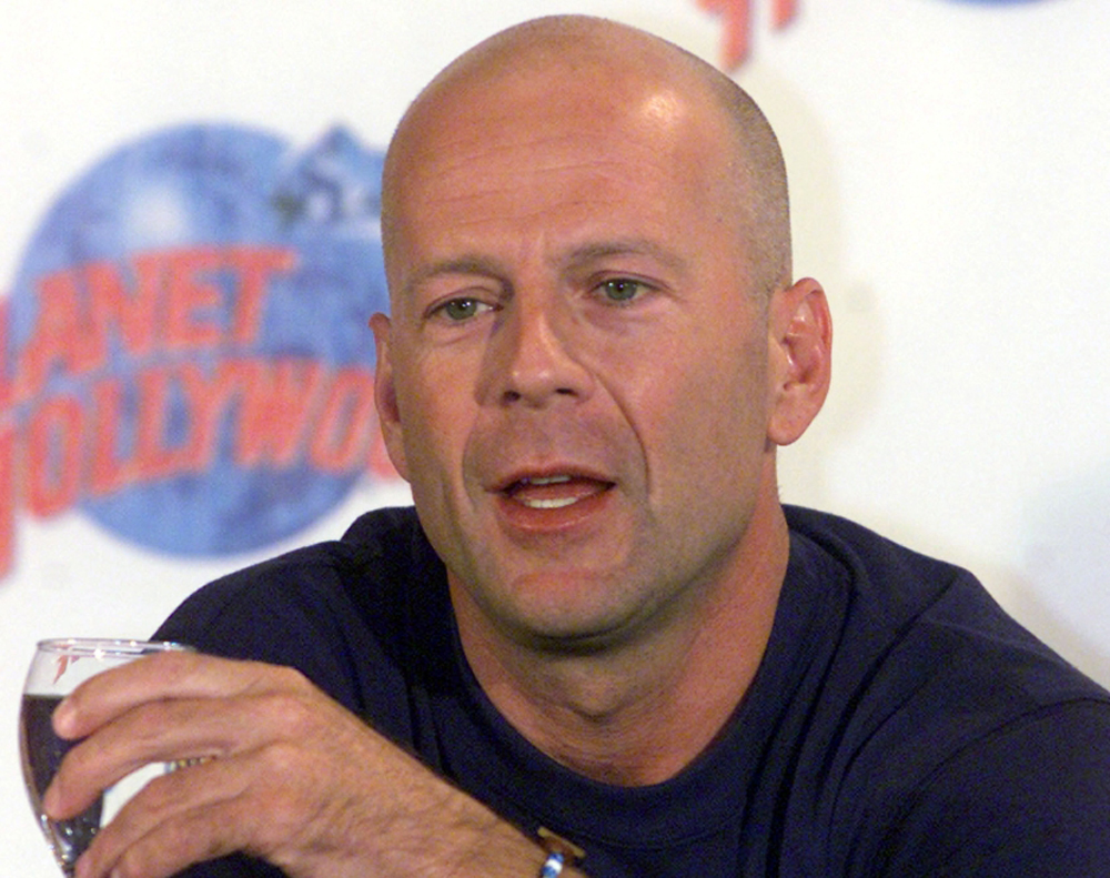 Hollywood star Bruce Willis talks to reporters during a news conference in a Planet Hollywood restaurant at a new cinema and shopping complex in an Athens suburb August 23, 2000. Willis is on a 24-hour visit to the Greek capital to promote the restaurant. YK/JRE/File Photo