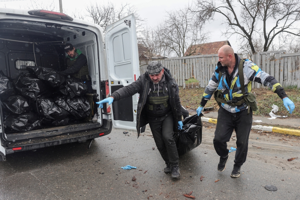 Volunteers prepare to put the body of a civilian, who according to residents was killed by Russian soldiers, in a van carrying body bags, amid Russia's invasion on Ukraine, in Bucha, in Kyiv region, Ukraine, April 3, 2022. REUTERS/Stringer
