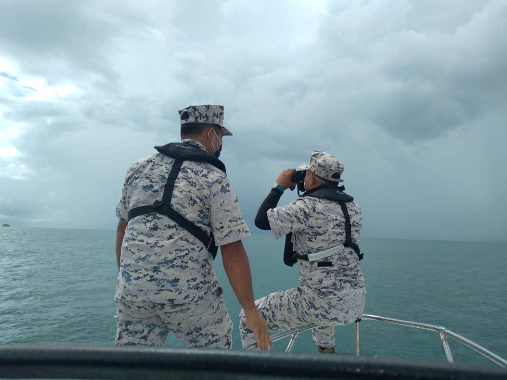 Malaysian Maritime Enforcement Agency (MMEA) officers search for the missing divers during the search and rescue operation off the Mersing coast, Johor, Malaysia, April 8, 2022. Malaysian Maritime Enforcement Agency/Handout via REUTERS