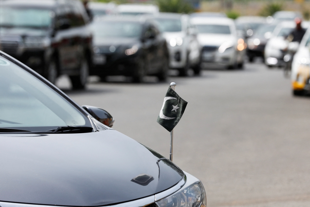 Pakistan's national flag is seen mounted on a vehicle of a member of the National Assembly, as a convoy of vehicles arrives at the Parliament House building in Islamabad, Pakistan April 11, 2022. REUTERS/Akhtar Soomro