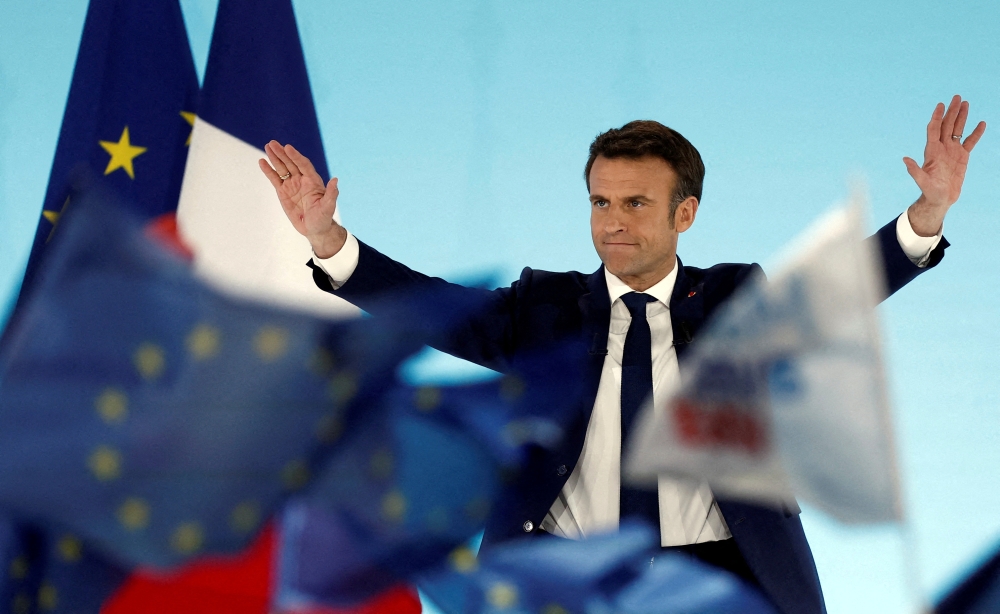 French President Emmanuel Macron, candidate for his re-election, reacts on stage after partial results in the first round of the 2022 French presidential election, in Paris, France, April 10, 2022. REUTERS/Benoit Tessier