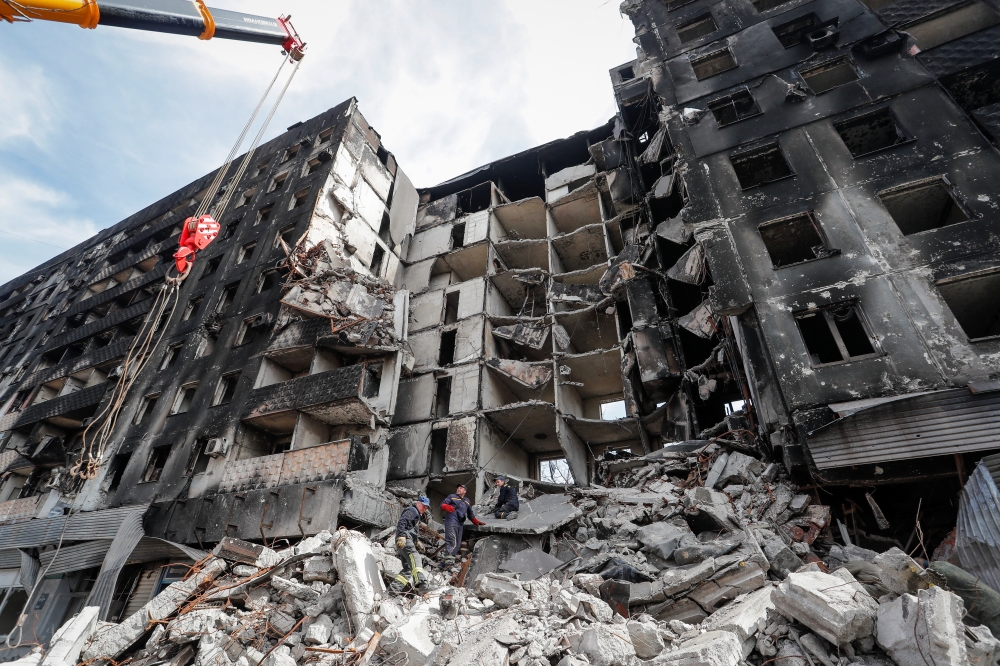 Emergency workers remove debris of a building destroyed in the course of the Ukraine-Russia conflict, in the southern port city of Mariupol, Ukraine April 10, 2022. REUTERS/Alexander Ermochenko
