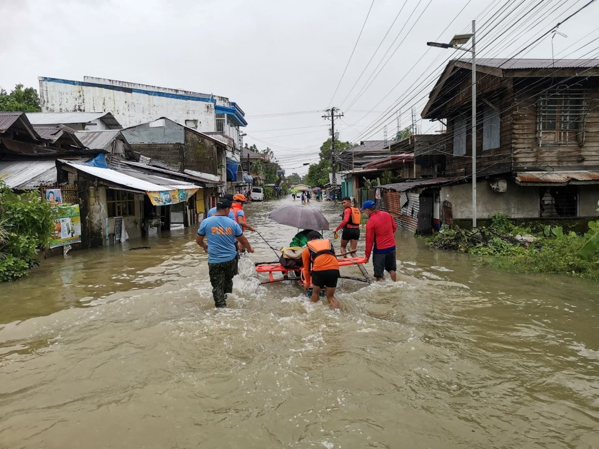 Rescuers push a woman in a raft on a flooded road, after the tropical storm Megi hit, in Leyte Province, Philippines April 10, 2022. Picture taken April 10, 2022. Philippine Coast Guard/Handout via REUTERS 