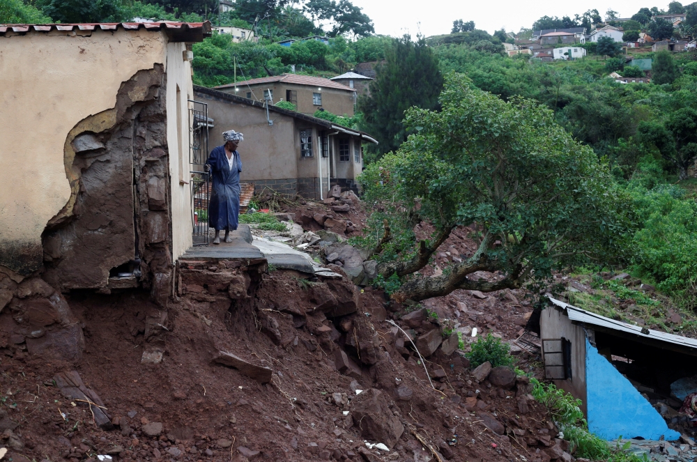 A woman stands at her front door after heavy rains caused flood damage in KwaNdengezi, Durban, South Africa, April 12, 2022. REUTERS/Rogan Ward