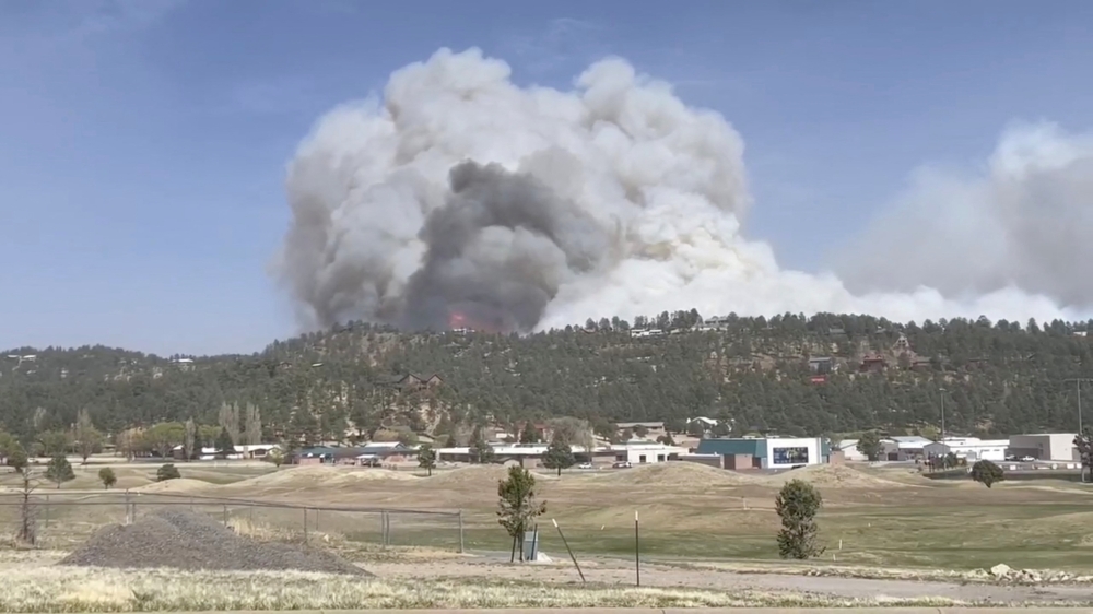 Smoke rises as a wind-driven wildfire, known as the McBride Fire, is seen burning on a ridge in Ruidoso, New Mexico, U.S. in this still image taken from a video obtained from social media April 12, 2022. Video taken April 12, 2022. Courtesy Melissa Gibbs/via REUTERS
