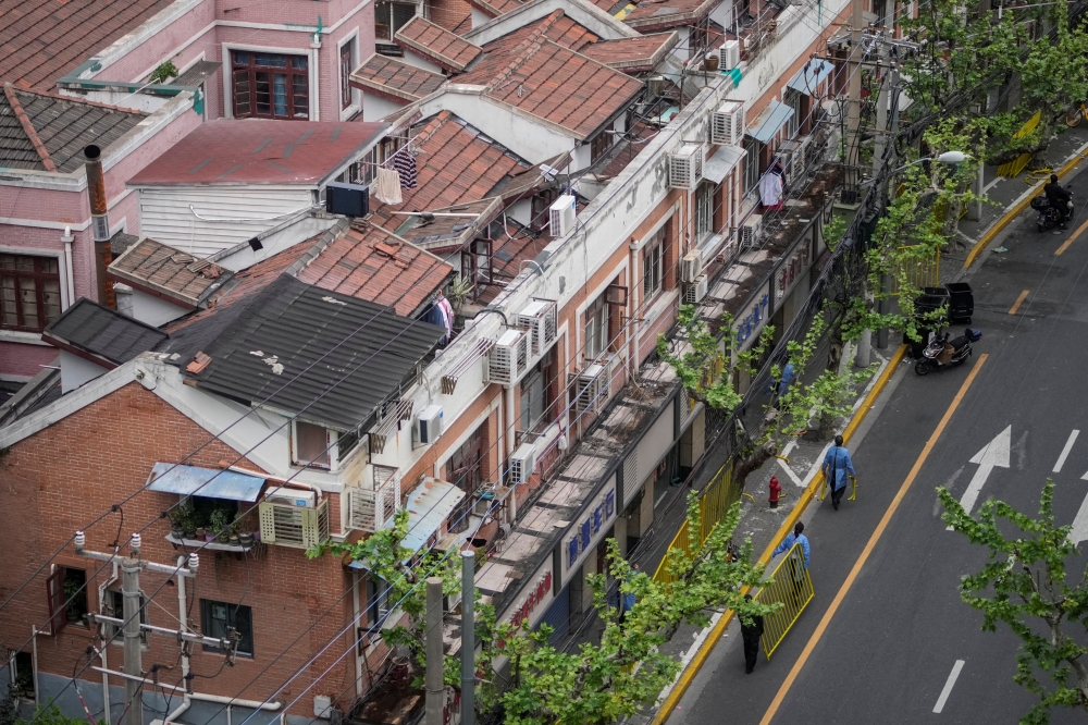 Workers carry a fence as they set up barriers to seal off an area during a lockdown in Shanghai, China, April 16, 2022. Reuters/Aly Song