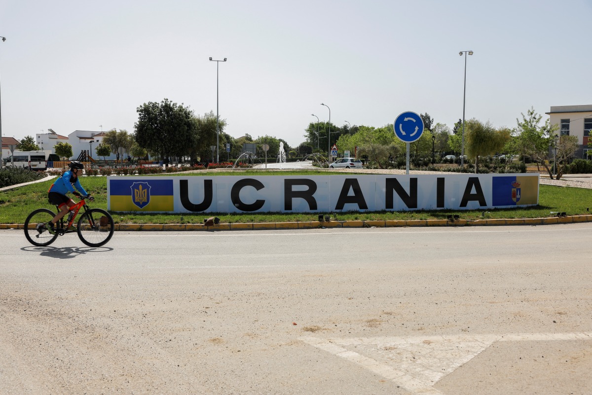 A cyclist rides past a sign in a roundabout that reads 'Ukraine' after it was changed from the original name of the town, as other street names were also changed to include names of Ukrainian cities in support of Ukraine, amid Russia's invasion, in the town of Fuentes de Andalucia, near Seville, southern Spain, April 16, 2022. REUTERS/Jon Nazca
