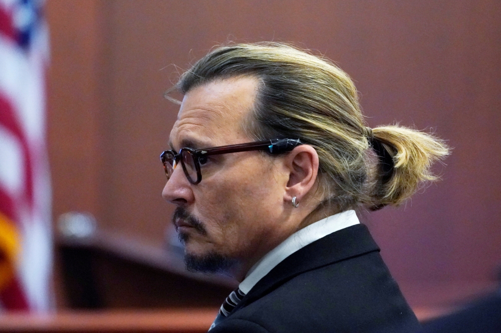 Actor Johnny Depp watches the jury leave as a lunch break starts during his defamation case against ex-wife Amber Heard at the Fairfax County Circuit Courthouse in Fairfax, Virginia, U.S., April 18, 2022. Steve Helber/Pool via REUTERS