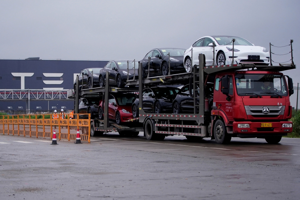 A truck transports new Tesla cars at its factory in Shanghai, China, May 13, 2021. REUTERS/Aly Song/File Photo