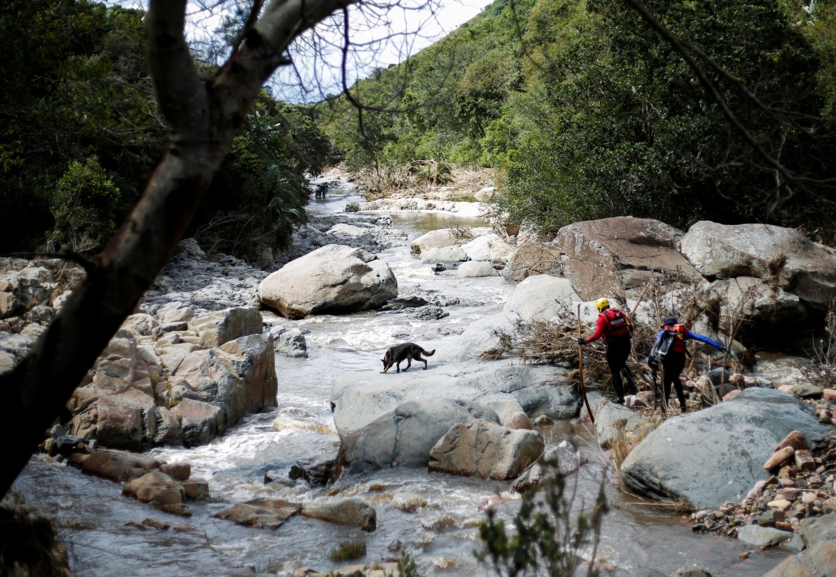 A search and rescue team uses a dog to search for bodies in Umbumbulu near Durban, South Africa, April 18, 2022. REUTERS/Rogan Ward
