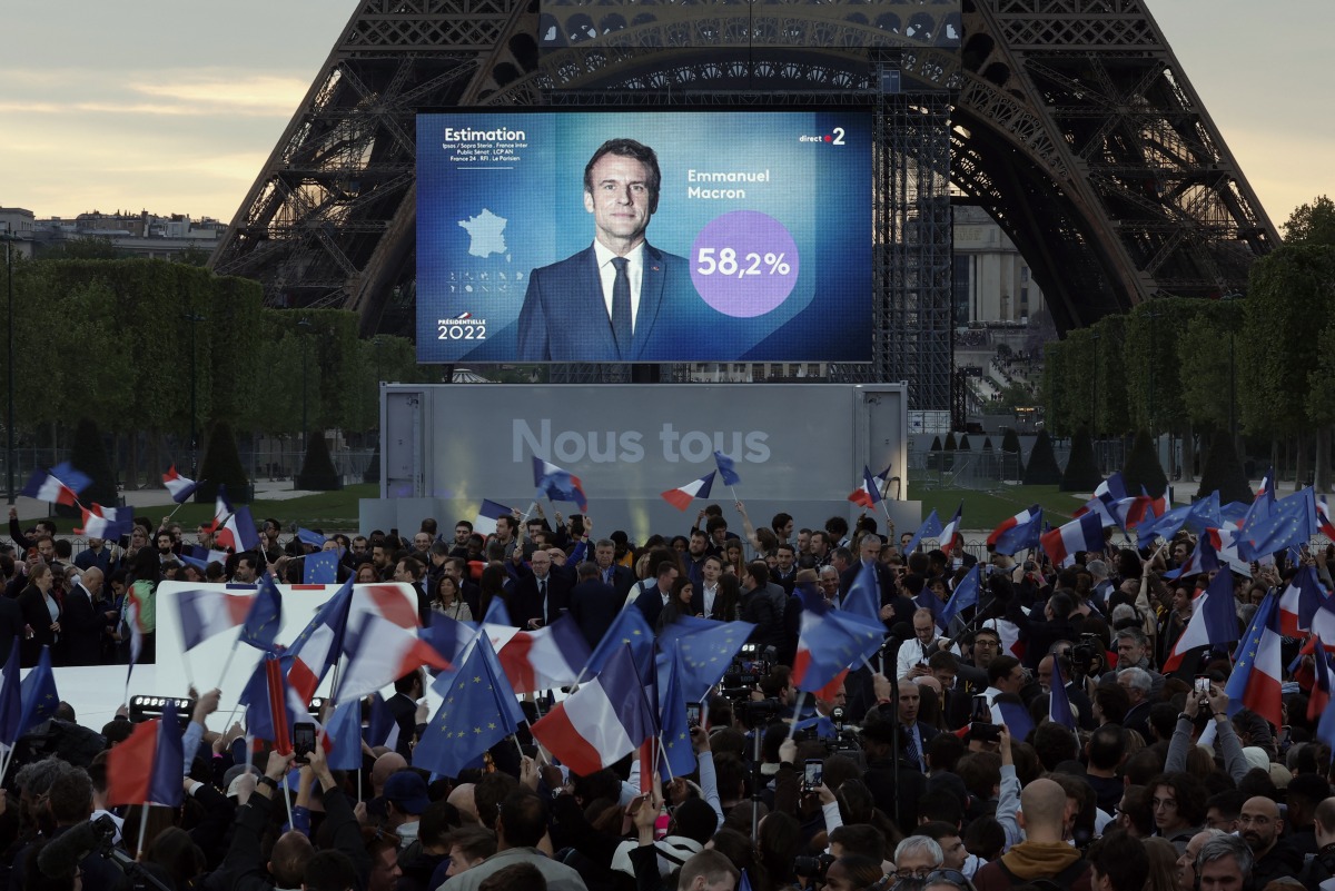 Supporters of French President Emmanuel Macron, candidate for his re-election, react after results were announced in the second round vote of the 2022 French presidential election, near Eiffel Tower, at the Champs de Mars in Paris, France April 24, 2022. REUTERS/Benoit Tessier
