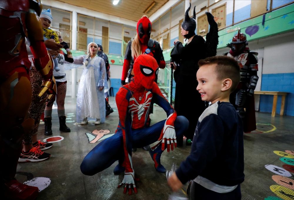 Argentine volunteer and member of the so-called Hero Club (Club de Heroes), Tomas Bensussan, who impersonates Spiderman, plays with the son of an inmate during a visit at the 33rd prison in Los Hornos as part of a wider program for vulnerable minors, on the outskirts of Buenos Aires, Argentina April 30, 2022. REUTERS/Agustin Marcarian