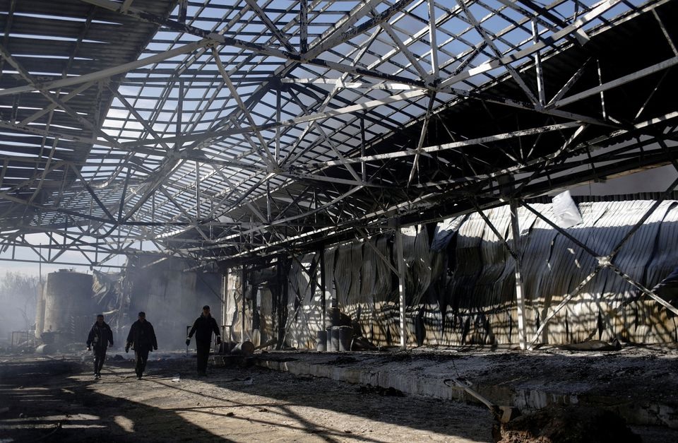 People walk at a damaged area inside a burning plant, following Russian shelling amid Russia's attack on Ukraine, in Kharkiv, Ukraine, April 30, 2022. REUTERS/Ricardo Moraes


