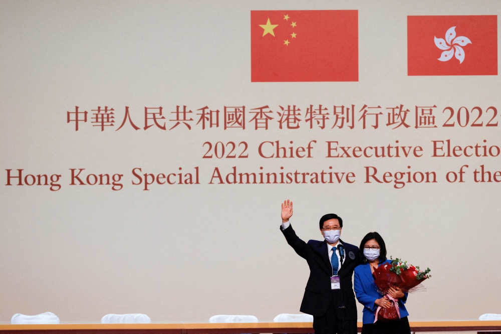 John Lee waves with his wife Janet Lam Lai-sim on stage after being elected as Hong Kong's Chief Executive, in Hong Kong, China, May 8, 2022. Reuters/Tyrone Siu