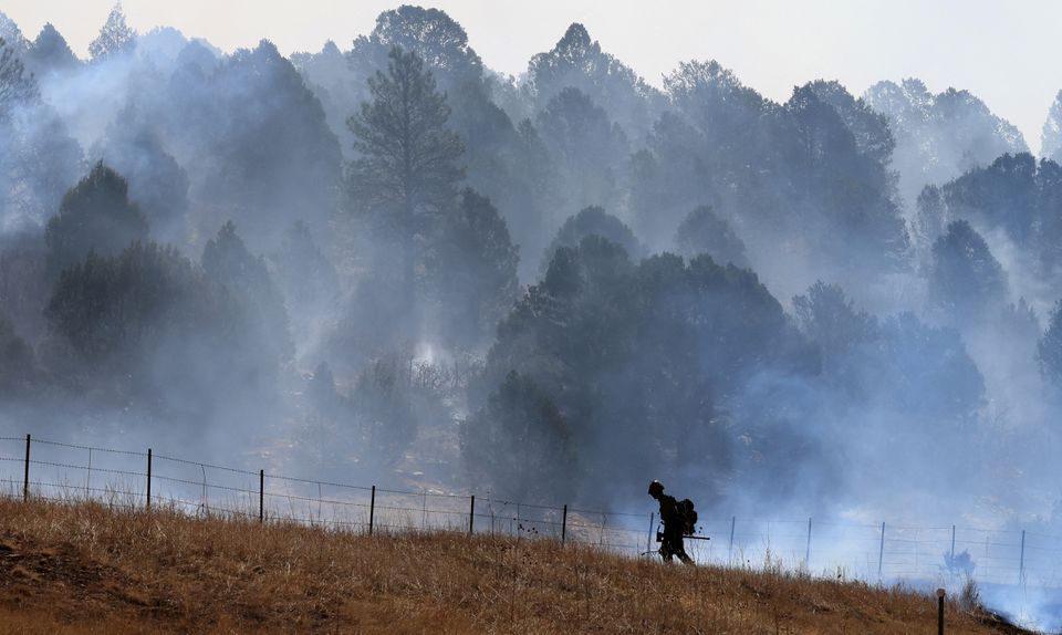 A firefighter works to combat the Hermits Peak and Calf Canyon wildfire, near Las Vegas, New Mexico, U.S. May 4, 2022. Picture taken May 4, 2022. REUTERS/Kevin Mohatt