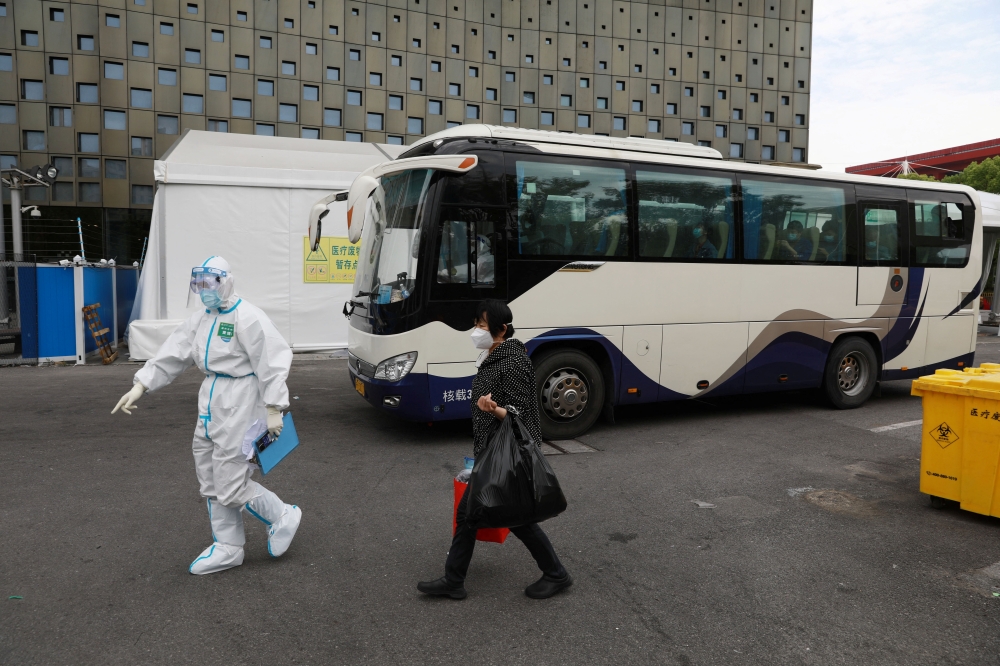 A patient who recovered from the coronavirus disease (COVID-19) leaves the makeshift hospital at the Shanghai World Expo Exhibition and Convention Centre in Shanghai, China May 9, 2022. Picture taken May 9, 2022. China Daily via REUTERS