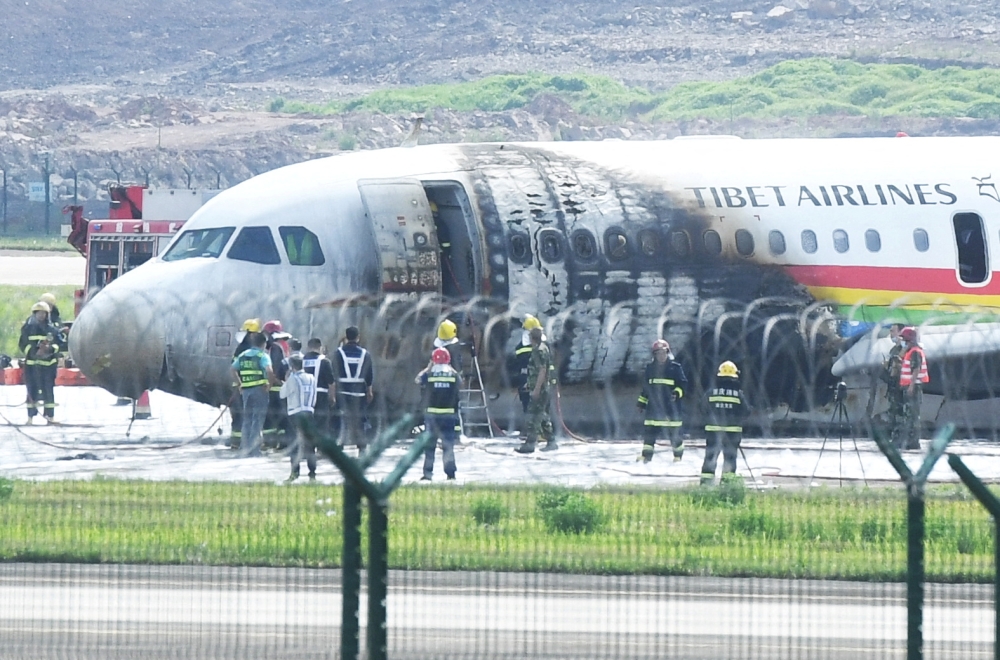Rescue workers are seen at the site where an Airbus A319 plane of Tibet Airlines caught fire after an aborted takeoff, at Chongqing Jiangbei International Airport in Chongqing, China May 12, 2022. cnsphoto via REUTERS