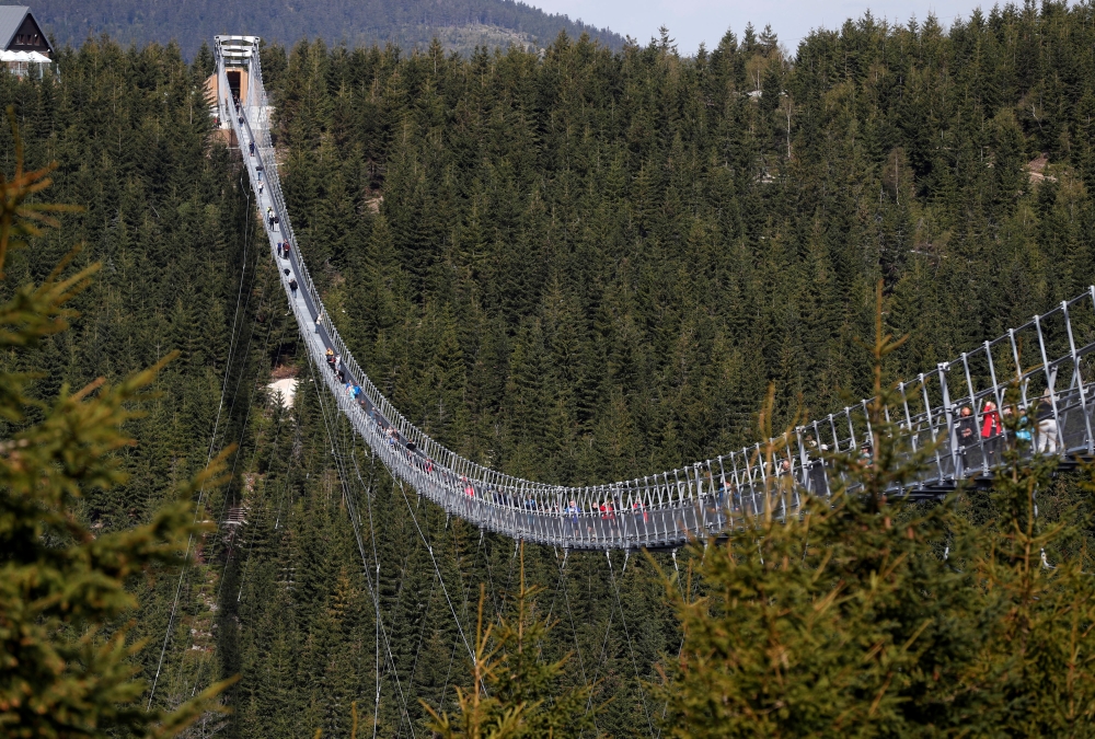 People walk across the newly-built world's longest suspension bridge after its official opening in the mountain resort of Dolni Morava, Czech Republic, May 13, 2022. REUTERS/David W Cerny