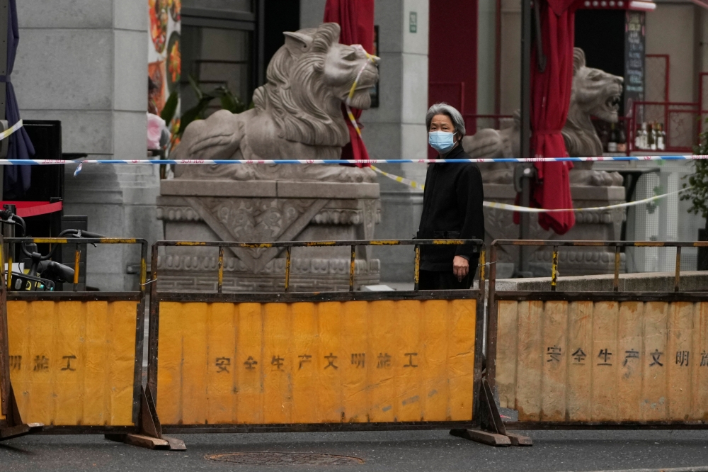 A woman walks on a closed street during lockdown, amid the coronavirus disease (COVID-19) pandemic, in Shanghai, China, May 13, 2022. REUTERS/Aly Song