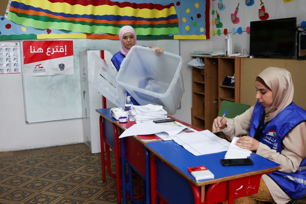 An electoral worker shows an empty ballot box at a polling station before it opens for the parliamentary election, in Beirut, Lebanon May 15, 2022. REUTERS/Mohamed Azakir