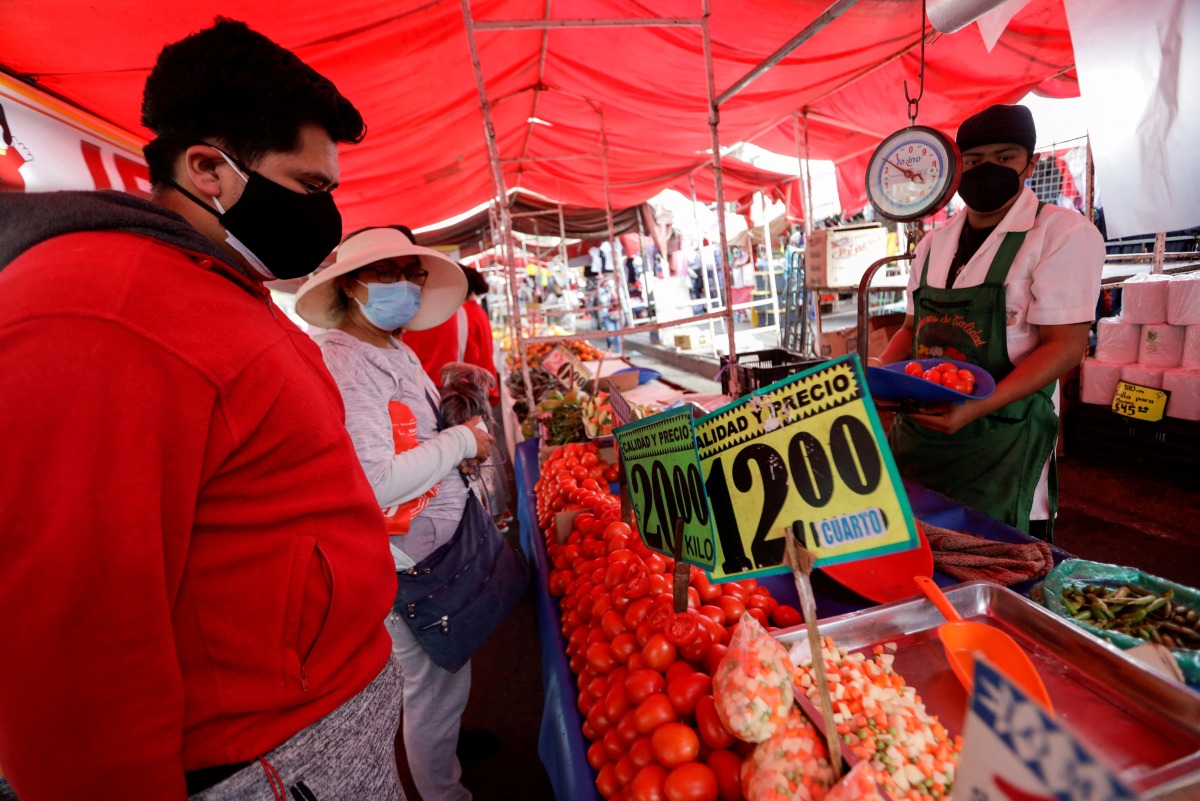 FILE PHOTO: Customers buy tomatoes at a street market, in Mexico City, Mexico December 17, 2021. REUTERS/Luis Cortes/File Photo
