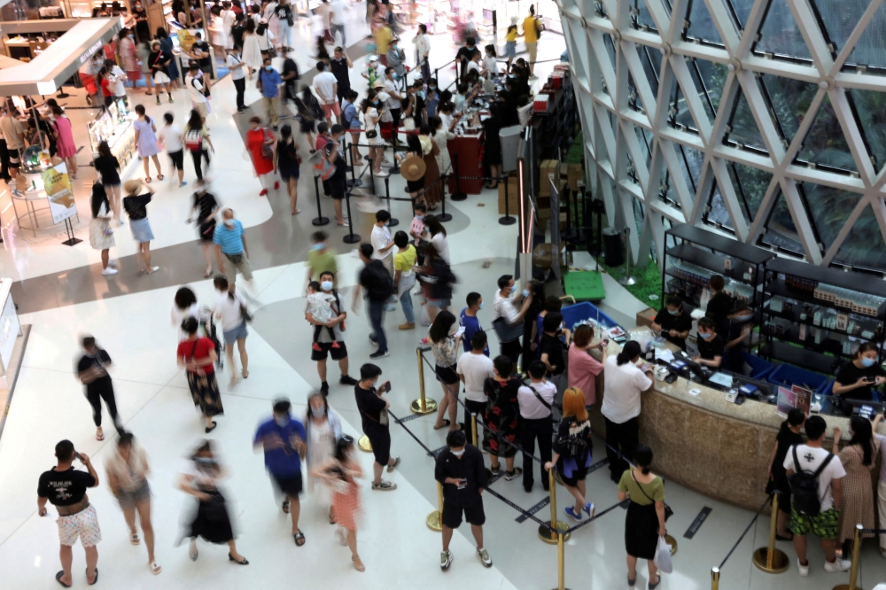 People wearing face masks following the coronavirus disease (COVID-19) outbreak shop at the Sanya International Duty-Free Shopping Complex in Sanya, Hainan province, China November 25, 2020. Picture taken November 25, 2020. REUTERS/Tingshu Wang
