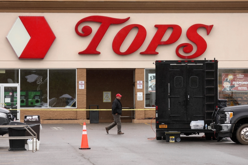 A Member of the FBI search for evidence at the scene of a weekend shooting at a Tops supermarket in Buffalo, New York, U.S. May 18, 2022. REUTERS/Brendan McDermid