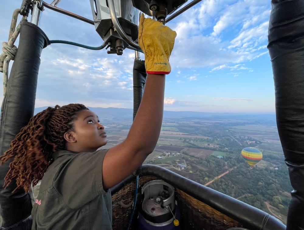 Semakaleng Mathebula, South Africa's first Black female hot-air balloon pilot releases propane gas into the burner of a hot-air balloon during a flight over Johannesburg, South Africa, May 15, 2022. REUTERS/Shafiek Tassiem NO RESALES. NO ARCHIVES