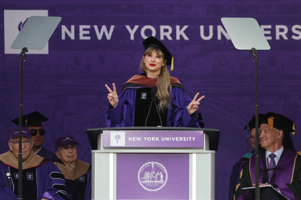Singer Taylor Swift gestures while speaking after receiving her Honorary Doctorate in Fine Arts during the New York University (NYU) graduation ceremony at Yankee Stadium in the Bronx borough of New York City, New York, U.S., May 18, 2022. REUTERS/Shannon Stapleton