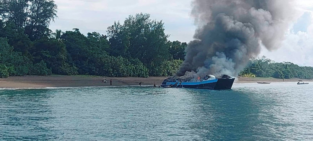 Smoke rises from a burning passenger vessel near Real, Quezon province, May 23, 2022. Philippine Coast Guard/Handout via REUTERS
