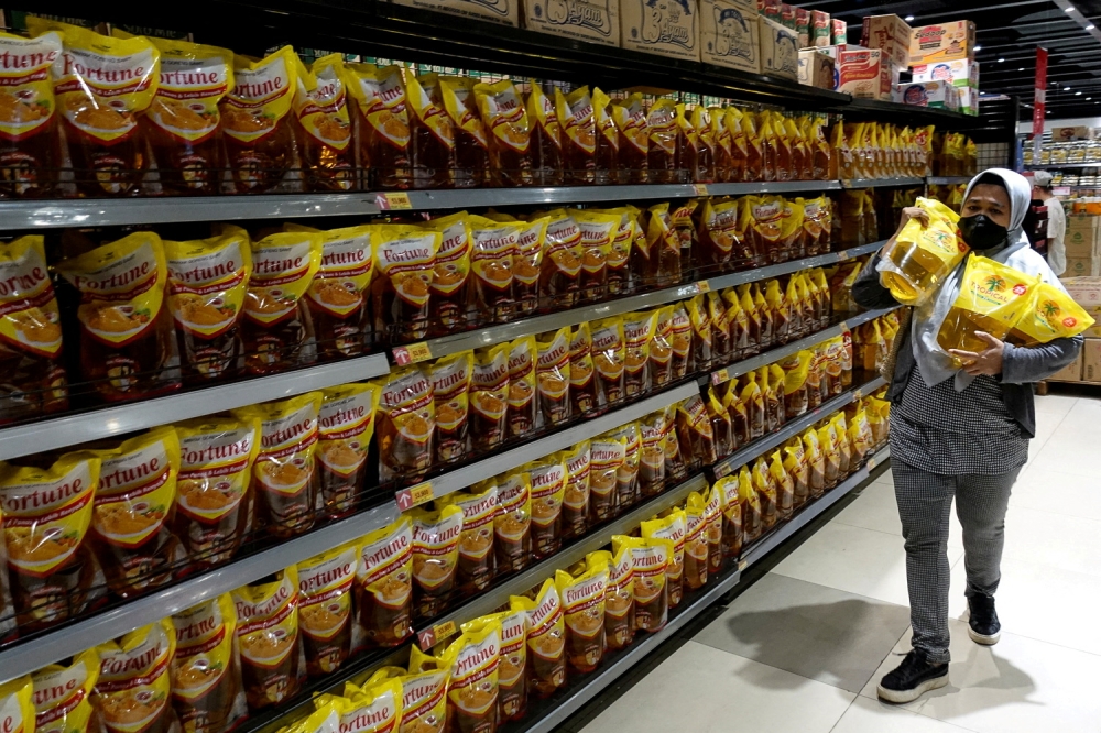 A woman shops for cooking oil made from oil palms at a supermarket in Jakarta, Indonesia, March 27, 2022. Reuters/Willy Kurniawan/File Photo