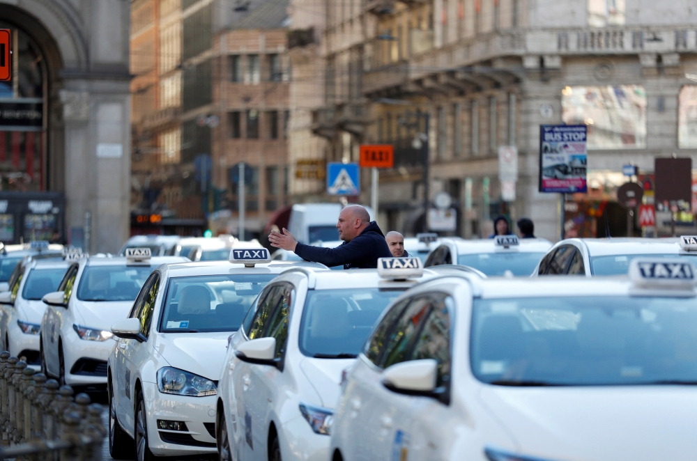 Taxi drivers wait for customers at Duomo square, as their services have been losing business since the country's coronavirus outbreak, in Milan, Italy February 28, 2020. REUTERS/Yara Nardi/File Photo