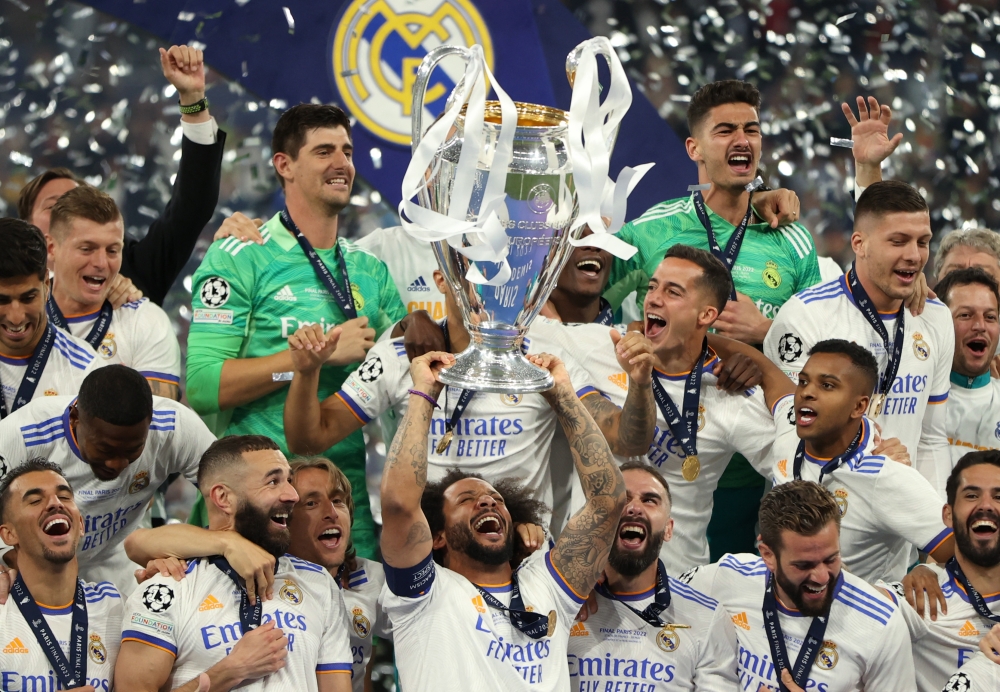 Real Madrid's Marcelo celebrates winning the champions league with the trophy and teammates REUTERS/Molly Darlington
