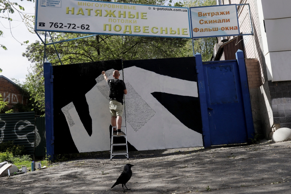 Ukrainian artist Gamlet Zinkivskiy works on his new painting, amid Russia's attack on Ukraine, in Kharkiv, Ukraine, May 13, 2022. Reuters/Ricardo Moraes