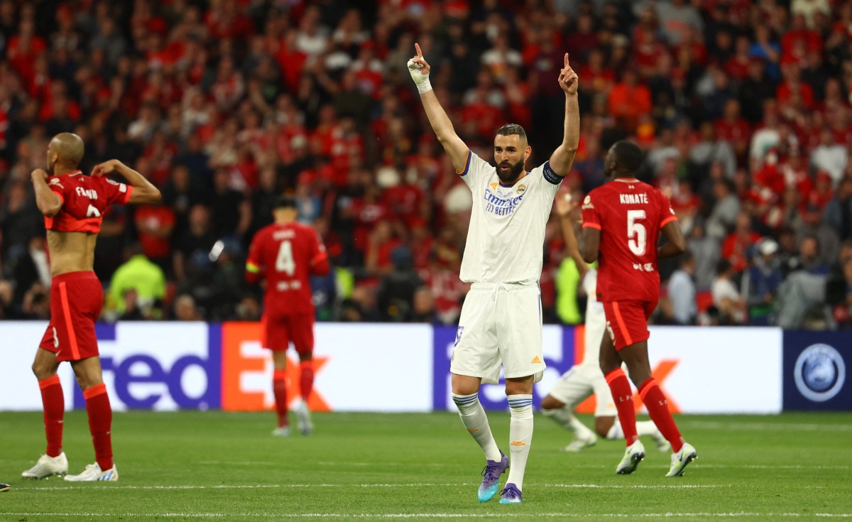 Real Madrid's Karim Benzema celebrates after winning the Champions League as Liverpool players look dejected REUTERS/Kai Pfaffenbach
