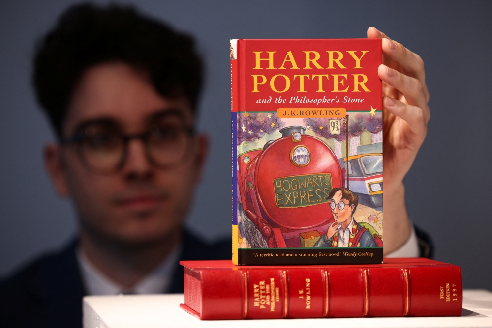 Rare Books Specialist and curator Mark Wiltshire poses with a rare first edition and signed by the author copy of 'Harry Potter and the Philosophers Stone' by British author J.K. Rowling. Reuters/Henry Nicholls