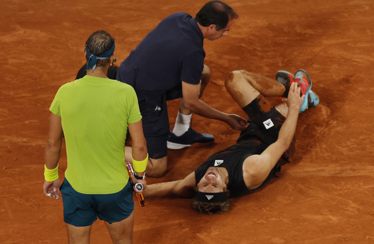 Germany's Alexander Zverev receives medical attention after sustaining an injury as Spain's Rafael Nadal looks on REUTERS/Gonzalo Fuentes
