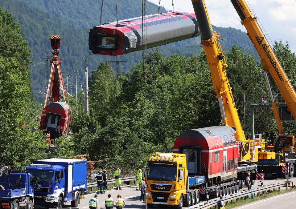 Carriages of a derailed regional train in which five people were killed and dozens injured are lifted onto trucks in Burgrain near the Bavarian town of Garmisch-Partenkirchen, Germany, June 6, 2022. Vifogra/Goppelt via REUTERS


