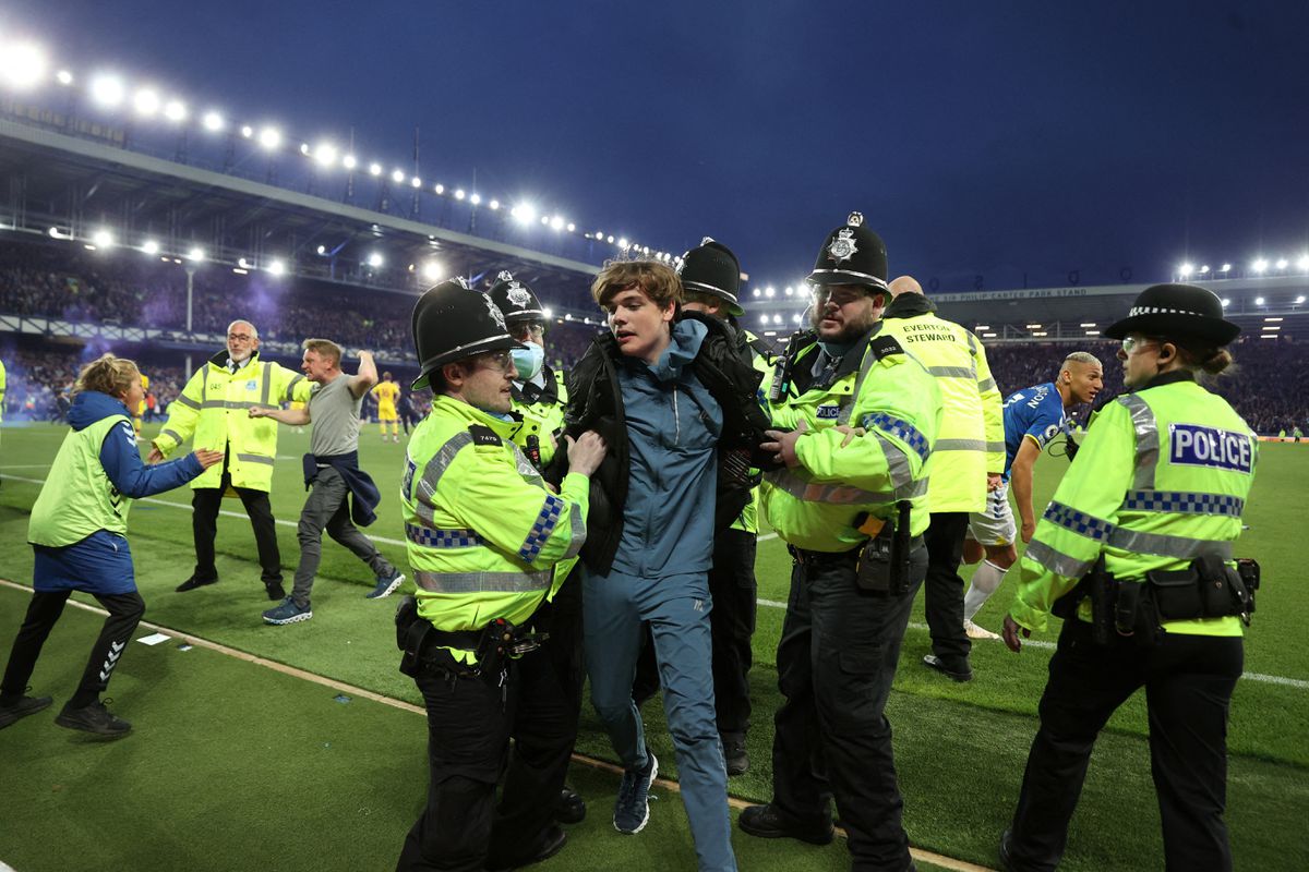 Police officer detain Everton fans as they celebrate avoiding relegation from the Premier League during a pitch invasion after the match Action Images via Reuters/Carl Recine

