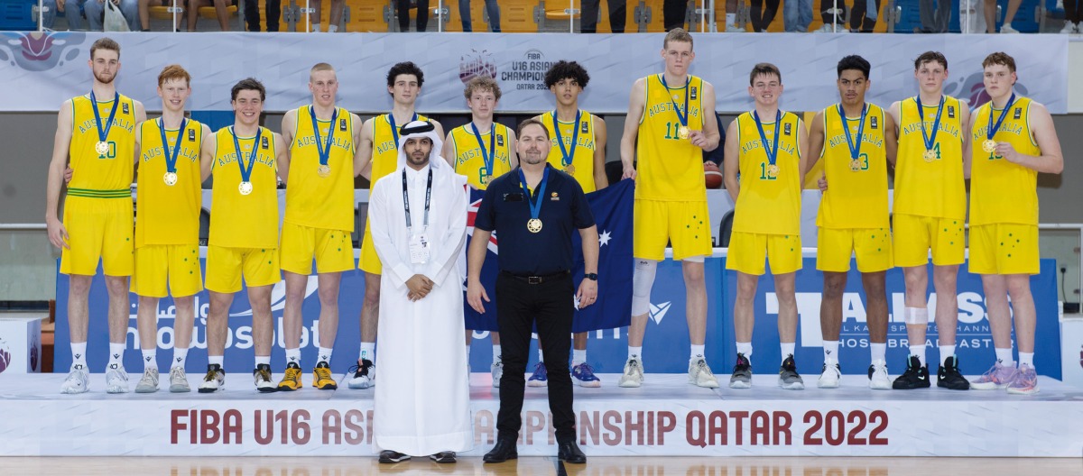 Qatar Basketball Federation President Mohammed Saad Al Mughaiseeb with the victorious Australia team players and coach Justin Schueller.