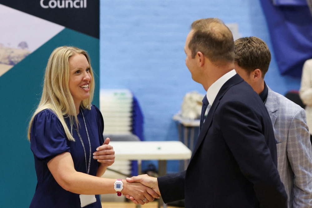 Liberal Democrats party candidate Richard Foord shakes hands with Conservative party candidate Helen Hurford afters results announced his win in the Tiverton and Honiton by-election, at Lords Meadow Leisure Centre in Devon, Britain, June 24, 2022. (REUTERS/Paul Childs)
