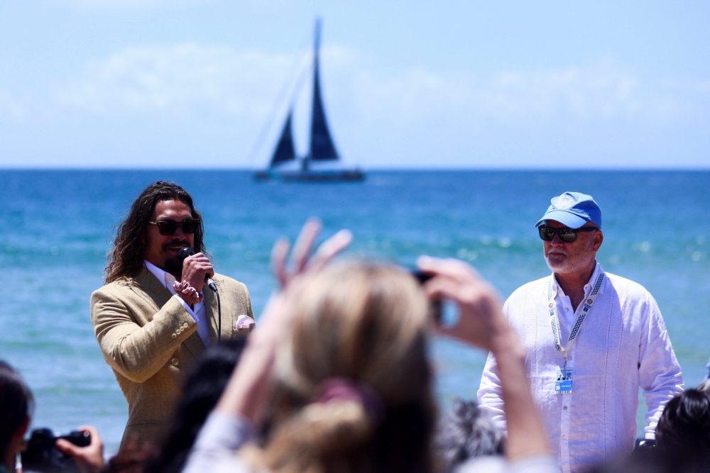 American actor and environmental activist Jason Momoa (left) and Peter Thomson, the United Nations Special Envoy for the Ocean, at a Portuguese Carcavelos beach ahead of the United Nations Ocean Conference in Lisbon, Portugal, on June 26, 2022. (Reuters/Pedro Nunes)
