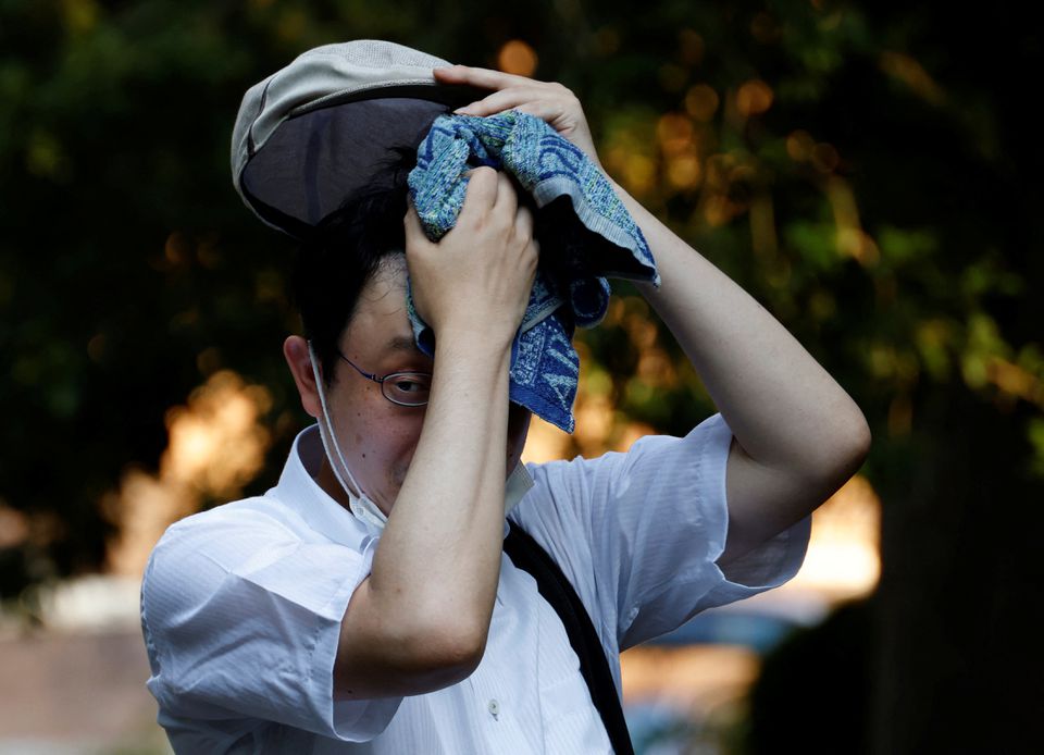 A man wipes off sweat with a towel at a park under the strain of Tokyo's hottest June streak since 1875 in Tokyo, Japan, June 30, 2022. REUTERS/Kim Kyung-Hoon



