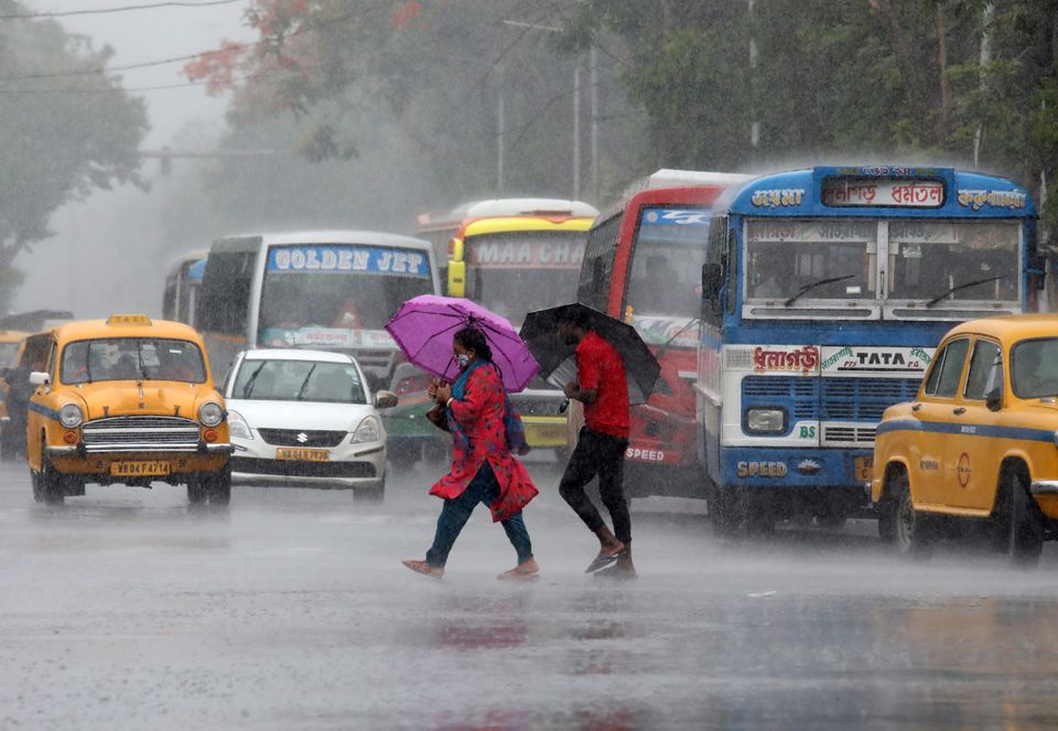 Commuters with umbrellas cross a road during heavy rains caused by Cyclone Asani, in Kolkata, India, May 10, 2022. REUTERS/Rupak De Chowdhuri/Files
