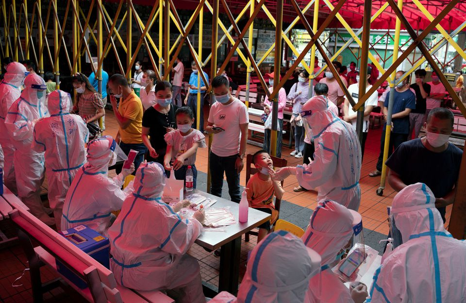 Residents line up for nucleic acid testing at a night market following a new case of the coronavirus disease (COVID-19) in Haikou, Hainan province, China August 3, 2021. China Daily via REUTERS/File Photo

