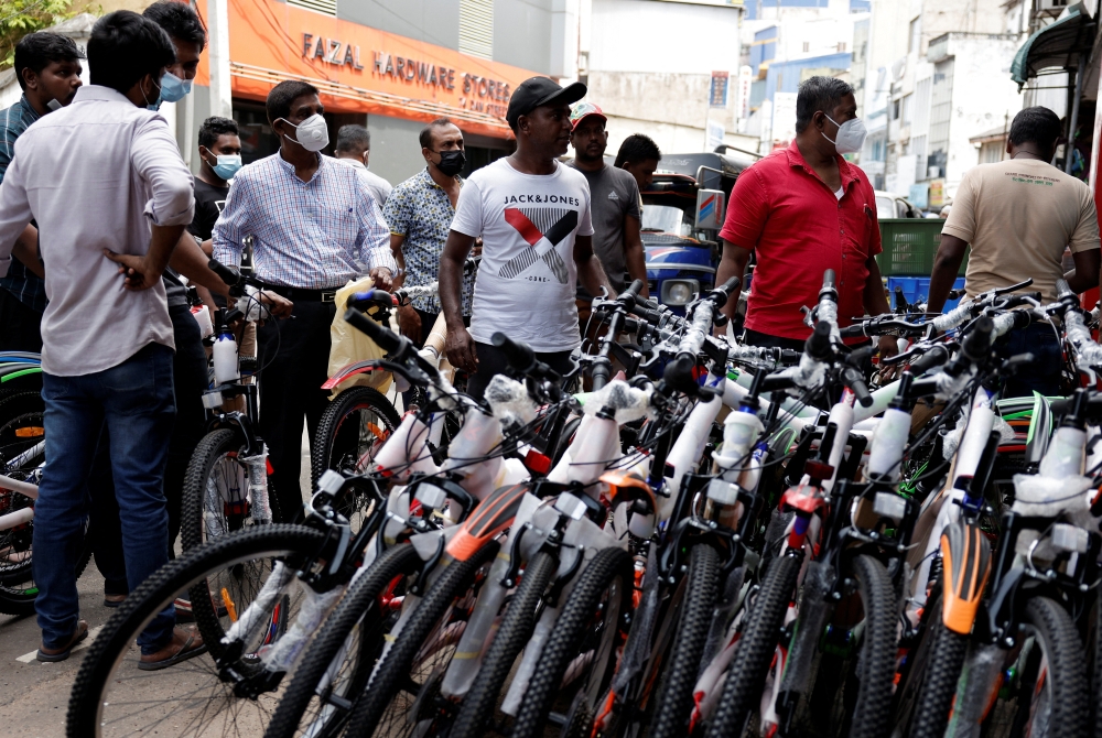 Customers wait outside a cycle shop to buy brand new cycles due to major fuel shortage, amid the country's economic crisis, in Colombo, Sri lanka, July 6, 2022. (Reuters/Dinuka Liyanawatte)