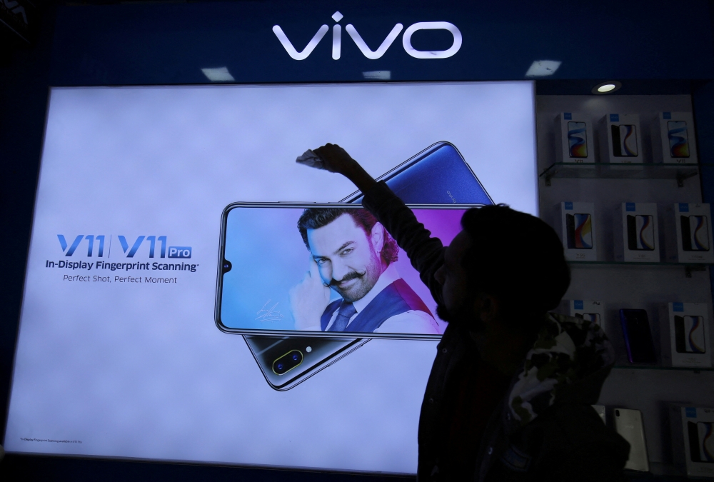 A man cleans a screen displaying a phone model of Chinese smartphone maker Vivo inside a shop in Ahmedabad, India, on December 14, 2018. (Reuters/Amit Dave)

